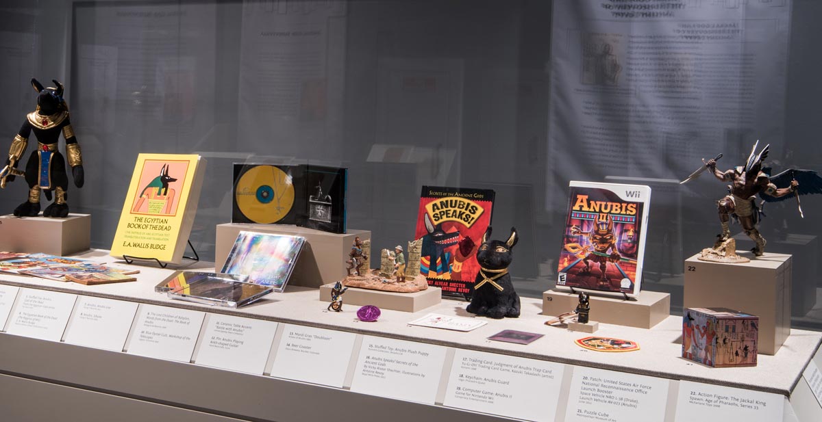 Exhibition case featuring modern representations of Anubis
